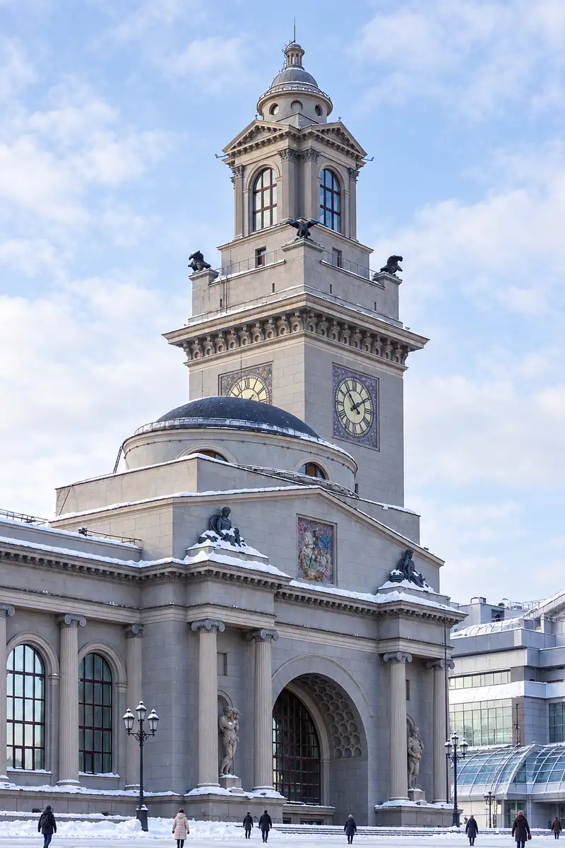 Tháp đồng hồ ga tàu Kievsky ở Moscow với bốn mặt đồng hồ, tượng đại bàng ở các góc và mái vòm nhỏ, tuyết mỏng phủ trên gờ đá