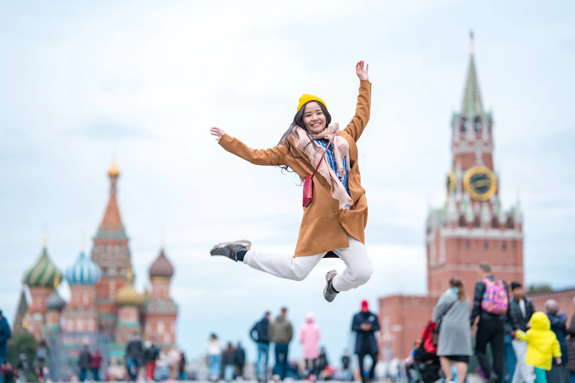 Nữ du khách Việt nhảy lên vui vẻ trên Quảng trường Đỏ, phía sau là nhà thờ Thánh Basil và tháp Spasskaya