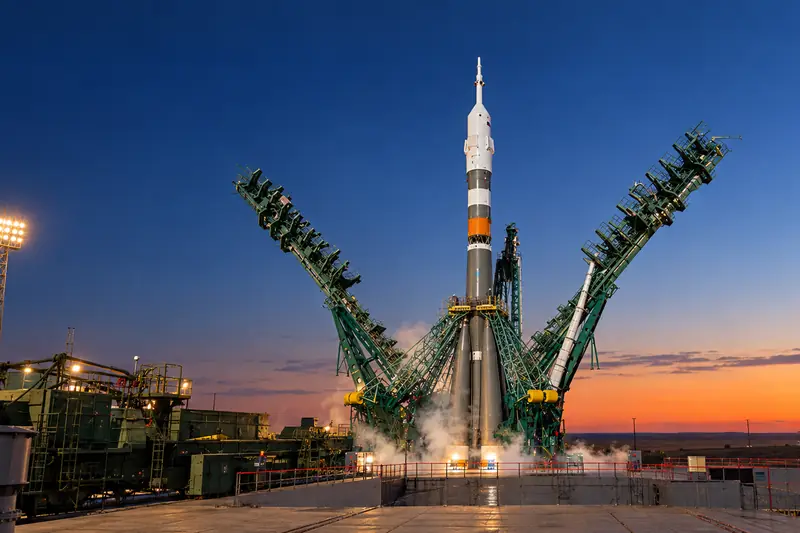 Tên lửa Soyuz đứng trên bệ phóng Baikonur lúc rạng đông, giàn đỡ xanh mở quanh thân